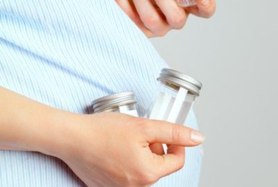 woman-holding-urine-sample-containers-pus-cells-urine-pregnancy